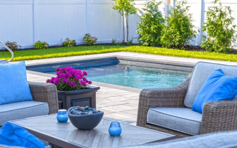 Outdoor garden seating with a pool behind - Puravida Custom Pools