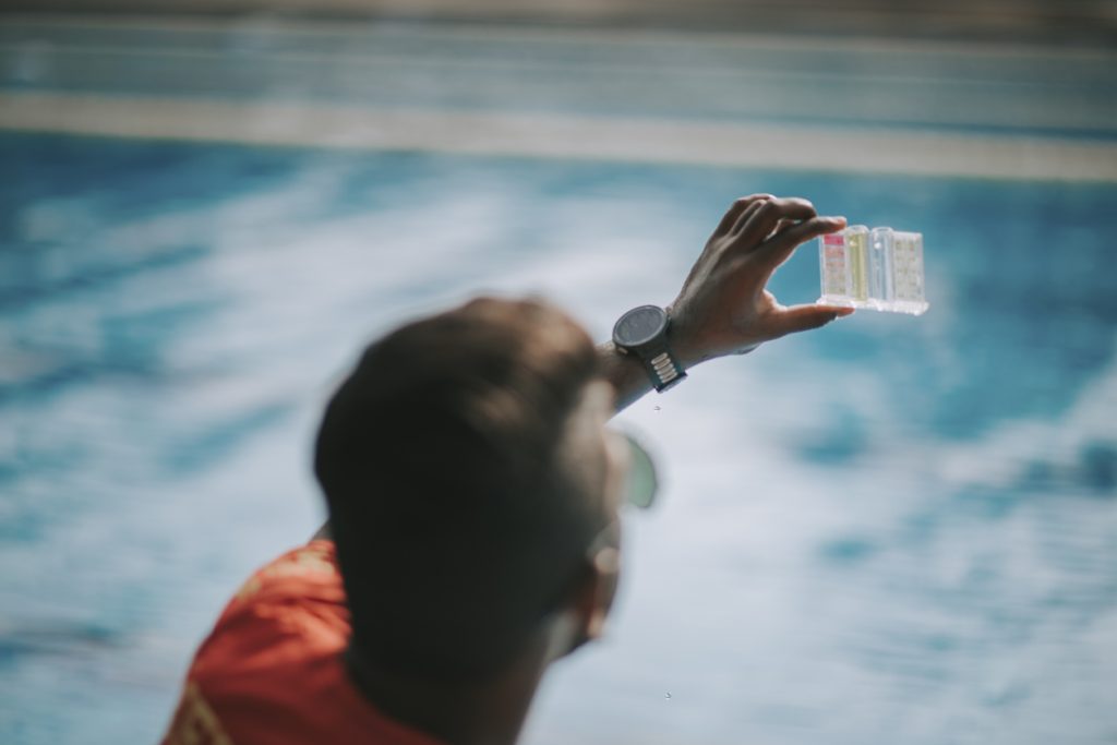 lifeguard Pool testing kit being used in a swimming pool for water chlorine level - Puravida Pools, NJ