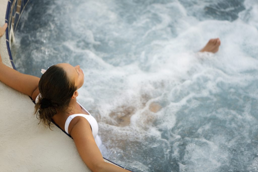 woman relaxing in a whirlpool hot tub - Puravida 