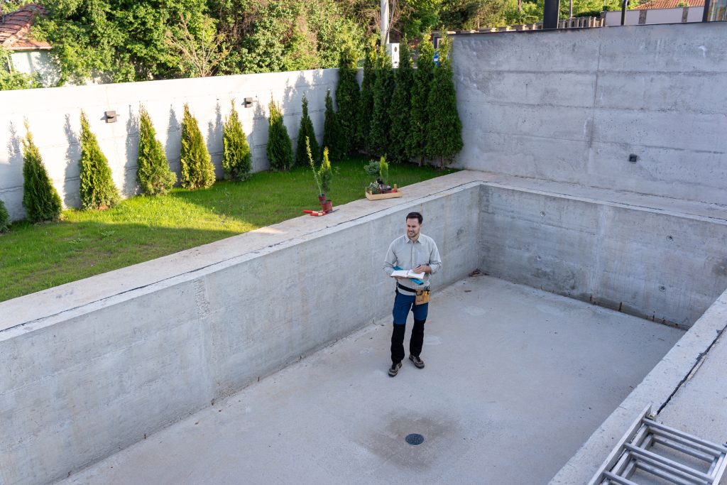 Master engineer inspecting the construction of a luxurious yard and swimming pool